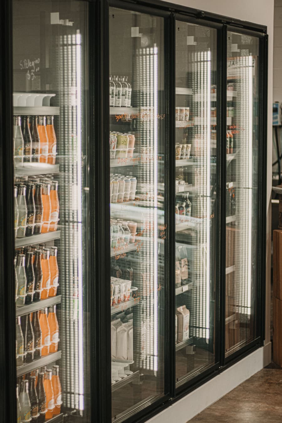 Glass-door display fridges lit along a grocer's aisle