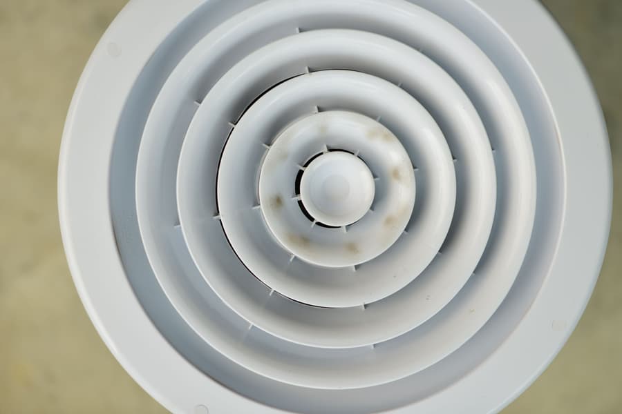 Round white ceiling diffuser from a ducted system