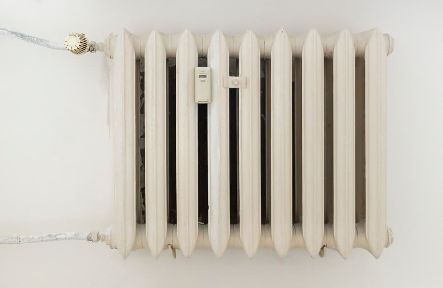 White cast-iron panel radiator with a thermostatic valve